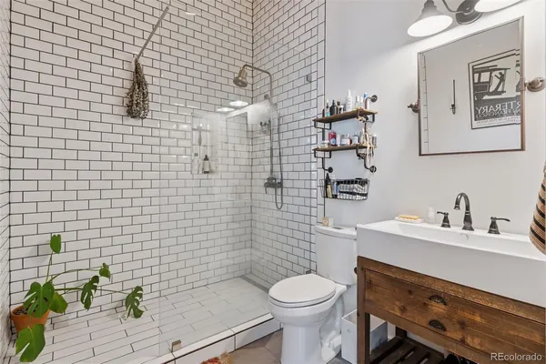 a bathroom with a sink a toilet and a mirror