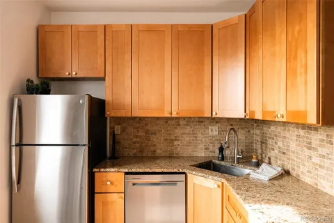 a kitchen with granite countertop a sink stainless steel appliances and cabinets