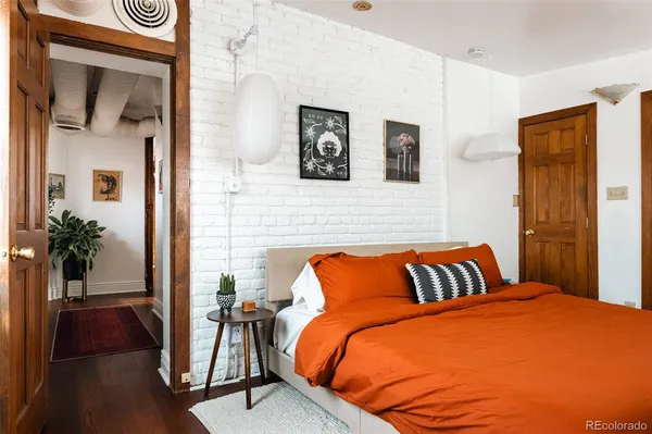 a bedroom with a bed and a potted plant