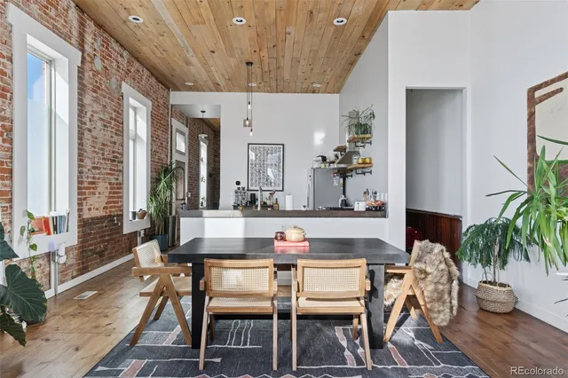 a dining room with furniture potted plants and wooden floor