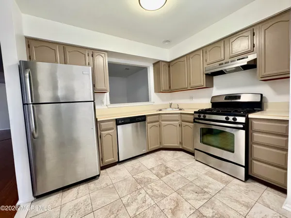 a kitchen with white cabinets stainless steel appliances and a sink