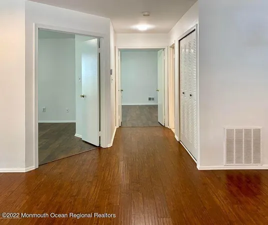 a view of a room with wooden floor and a ceiling fan