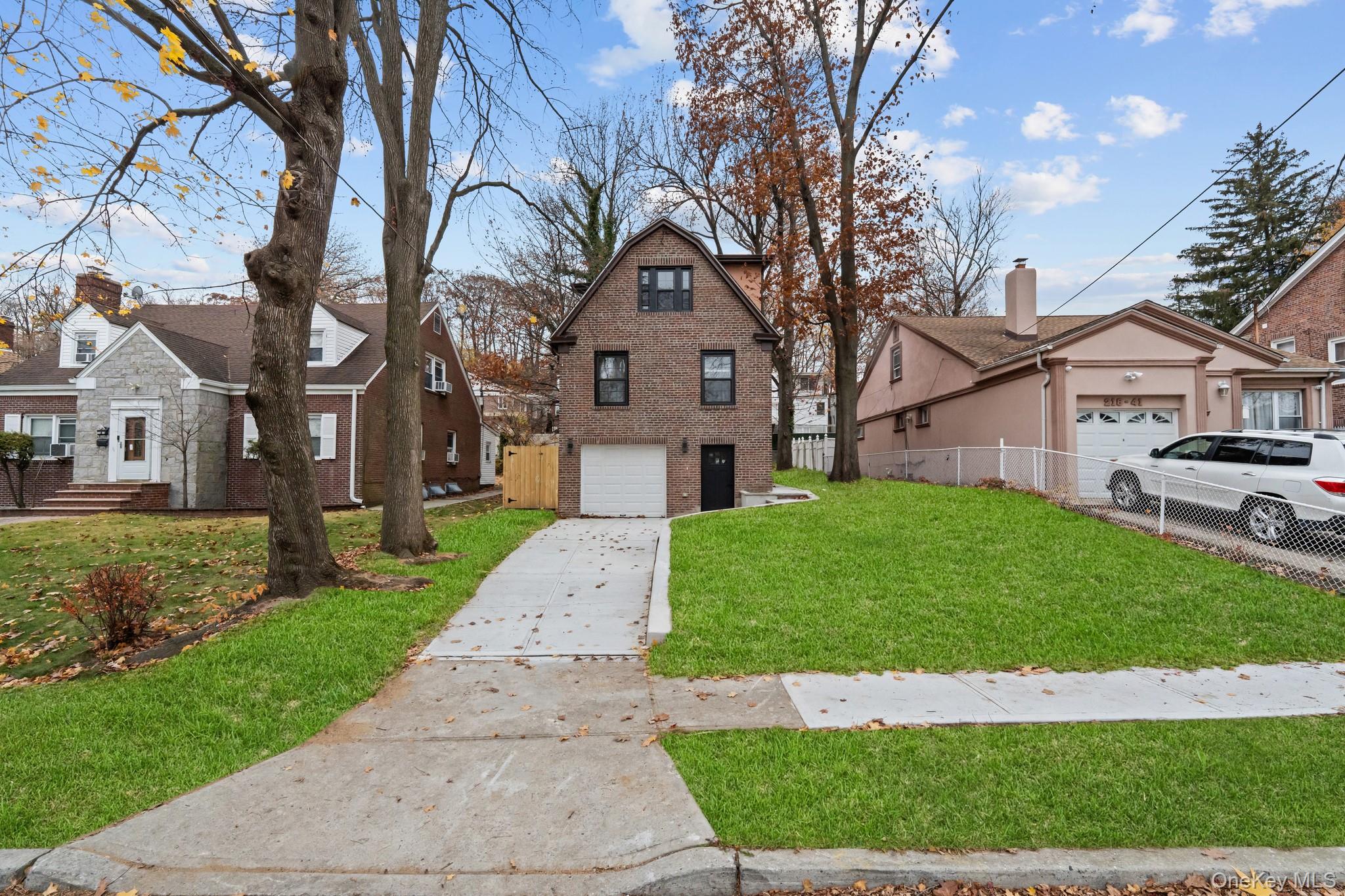 218-37 Spencer Avenue Queens, NY 11427 - Photo 11 of 31 View of front of home featuring concrete driveway, brick siding, and a residential view