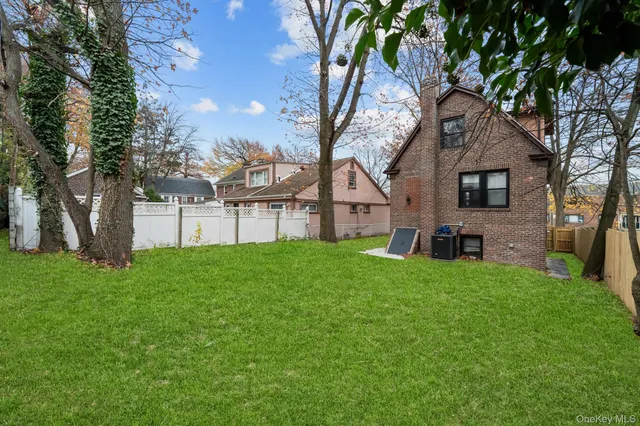 a view of a house with backyard and a tree
