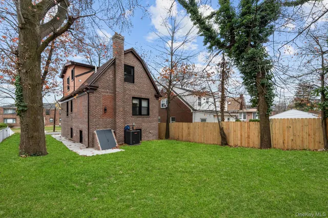 a view of a house with backyard and a tree