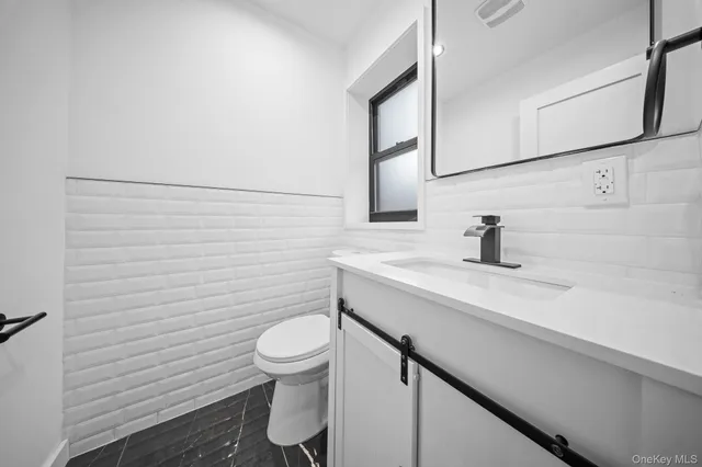 a bathroom with a toilet a sink and mirror