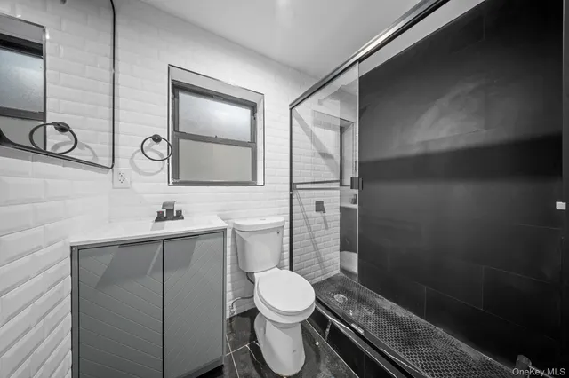 a bathroom with a toilet a sink and mirror