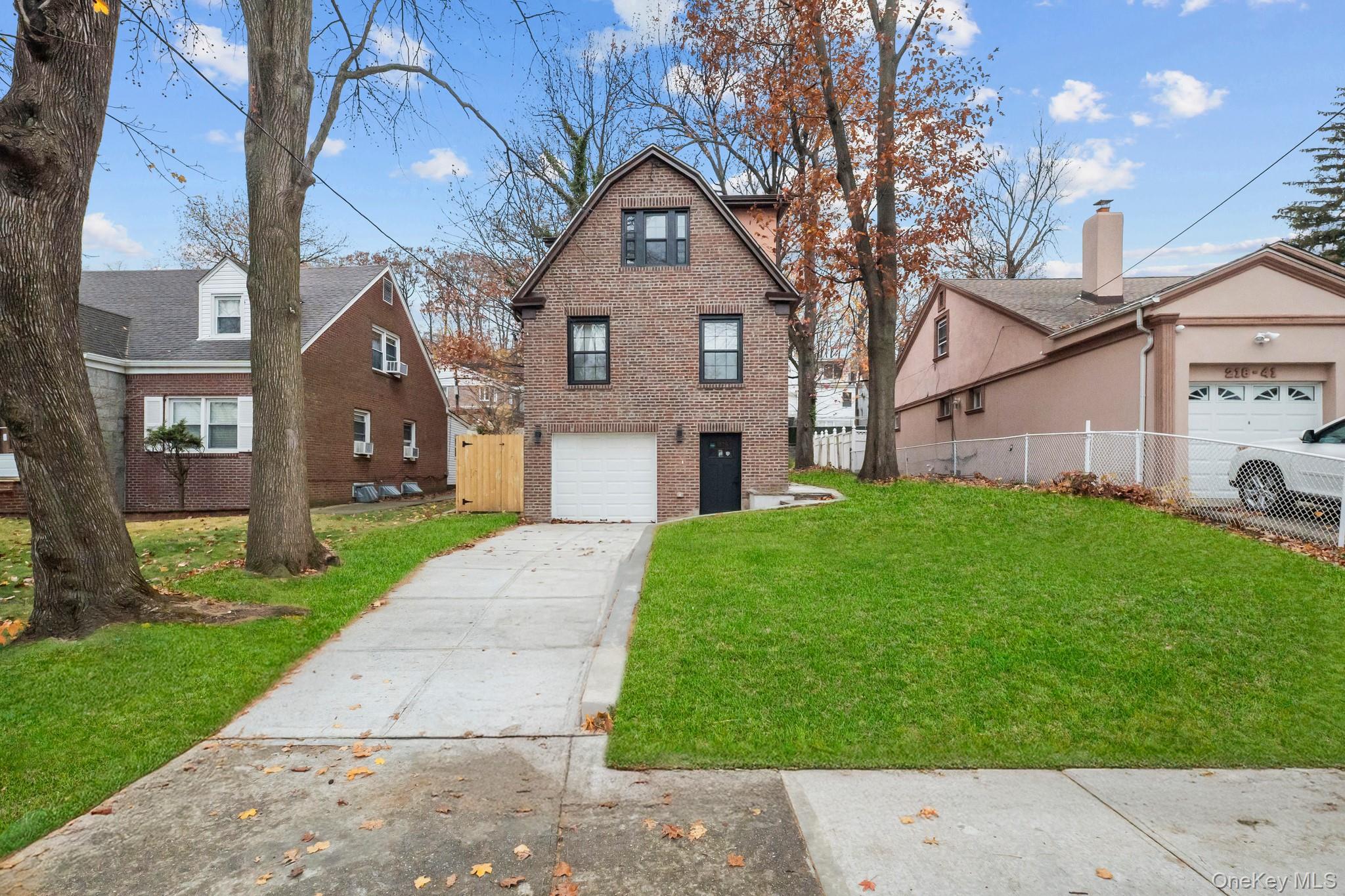 218-37 Spencer Avenue Queens, NY 11427 - Photo 20 of 31 View of front of property featuring brick siding, driveway, and an attached garage