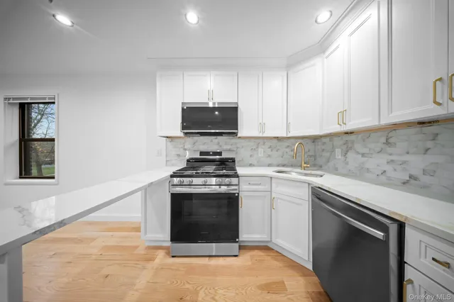 a kitchen with stainless steel appliances granite countertop a stove a sink and a microwave