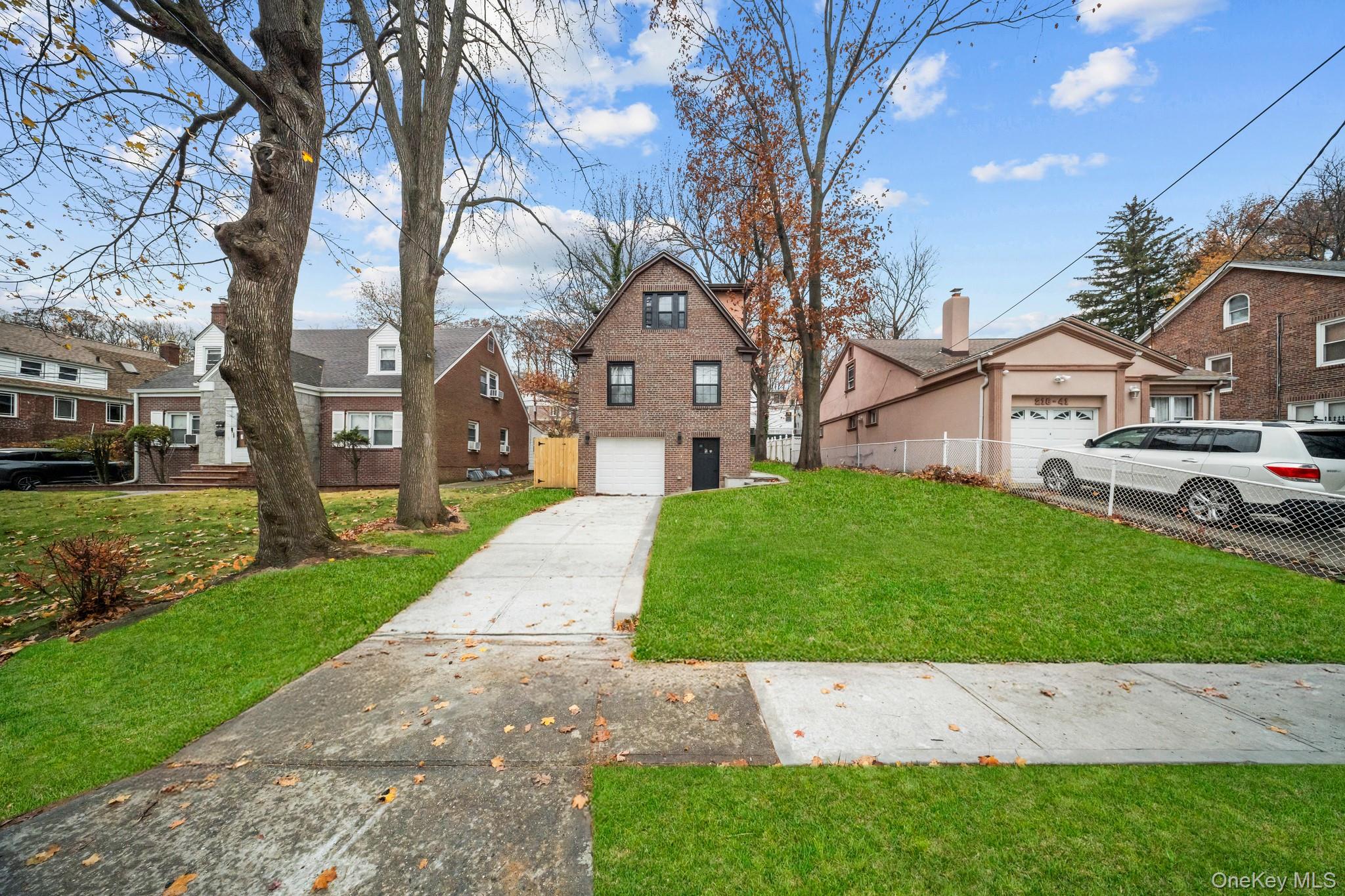 218-37 Spencer Avenue Queens, NY 11427 - Photo 25 of 31 View of front of property with a residential view, driveway, and a garage