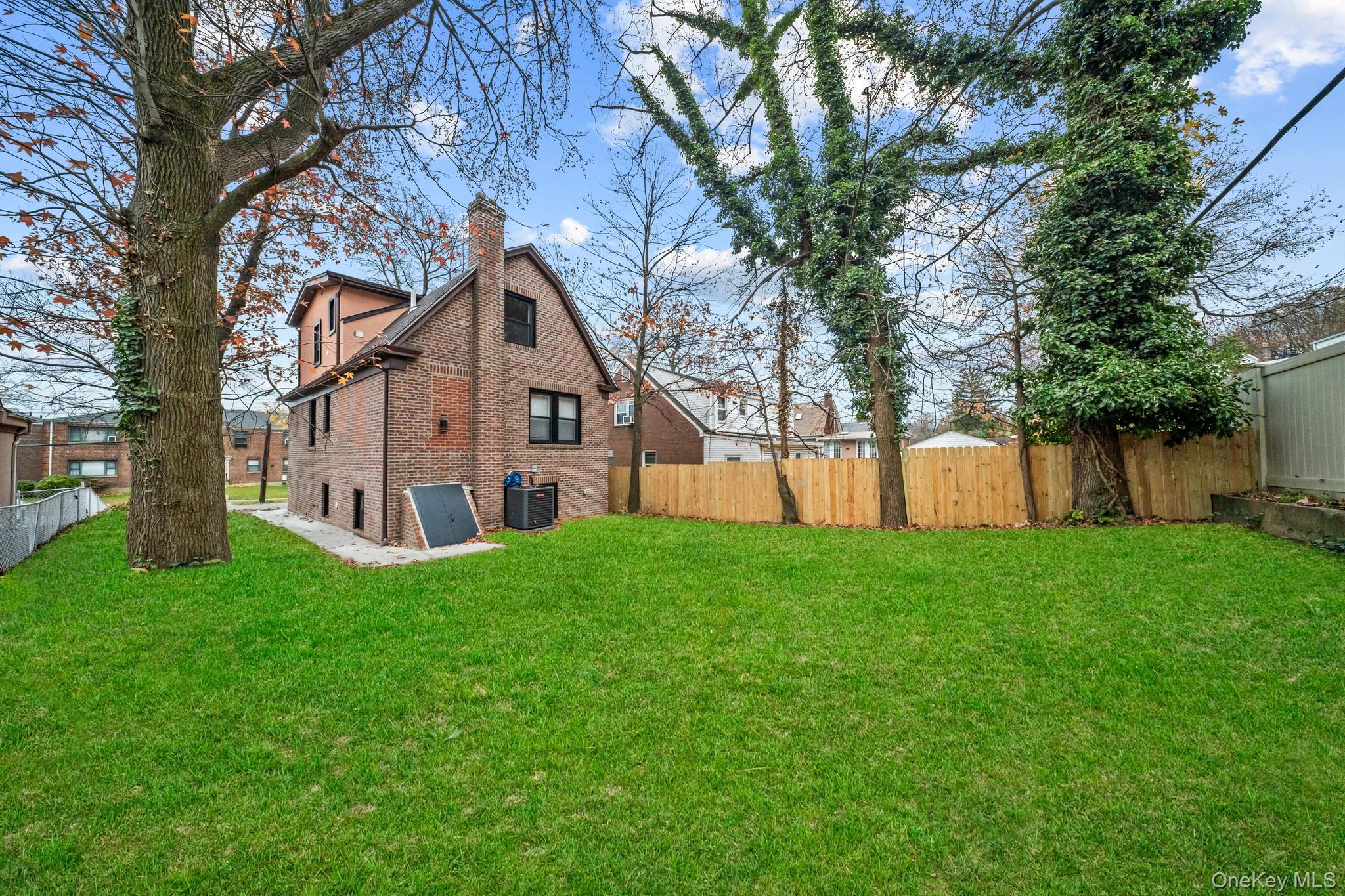218-37 Spencer Avenue Queens, NY 11427 - Photo 27 of 31 Back of property featuring brick siding and a chimney