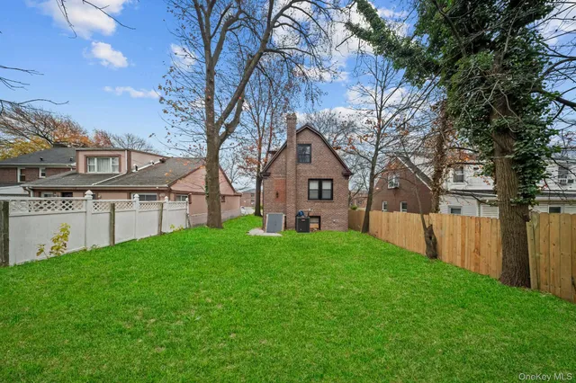 a view of a house with backyard and tree