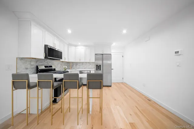 a kitchen with stainless steel appliances a refrigerator and a stove top oven