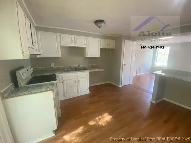 a kitchen with stainless steel appliances granite countertop a sink stove and cabinets