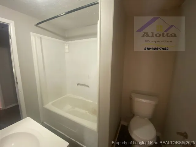 a white toilet sitting next to a bath tub