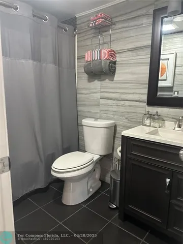 a bathroom with a sink vanity granite and toilet