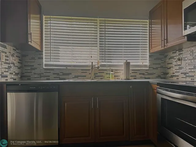 a kitchen with stainless steel appliances granite countertop a sink and a refrigerator