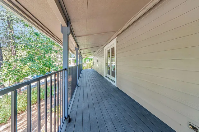 a view of an empty room with a window and kitchen view
