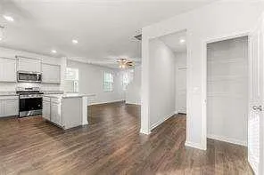 a large kitchen with a refrigerator and a stove top oven