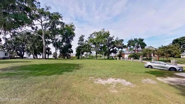 a view of a park with lots of trees and cars parked