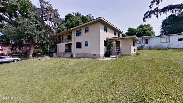 a front view of house with yard and trees in the background