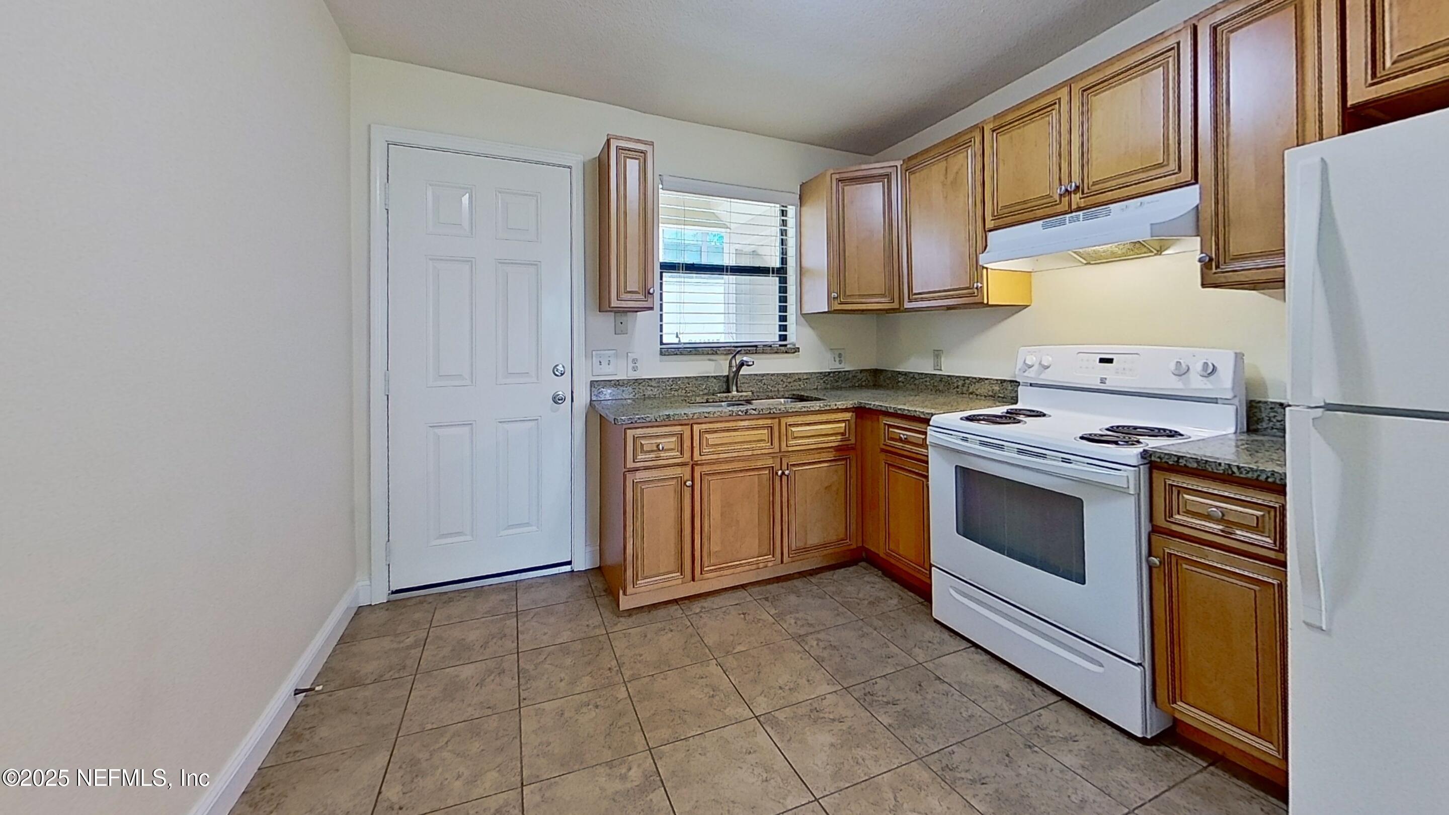 5148 Floral Bluff Road, Unit 2 Jacksonville, FL 32211 - Photo 4 of 13 a white kitchen with a stove top oven