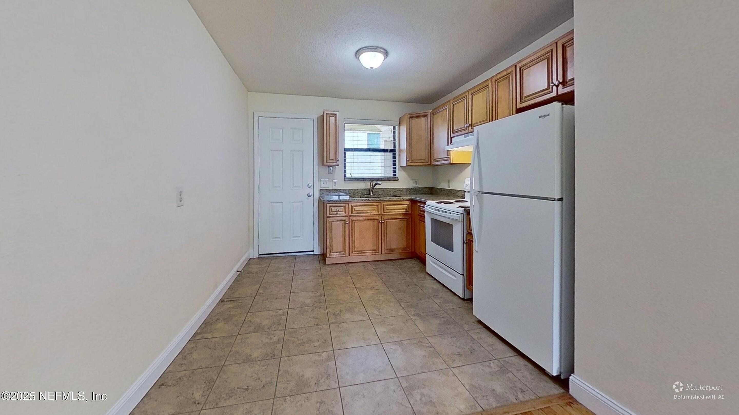 5148 Floral Bluff Road, Unit 2 Jacksonville, FL 32211 - Photo 5 of 13 a kitchen with a refrigerator sink stove and cabinets