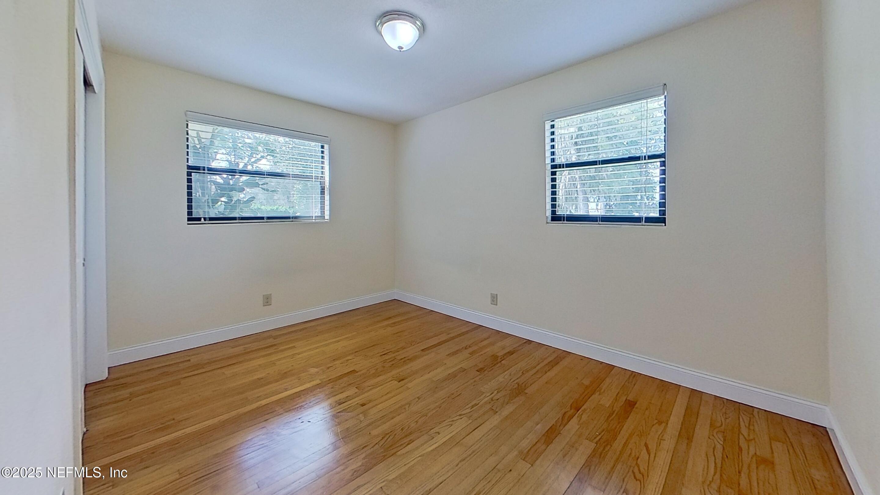 5148 Floral Bluff Road, Unit 2 Jacksonville, FL 32211 - Photo 8 of 13 an empty room with wooden floor and windows