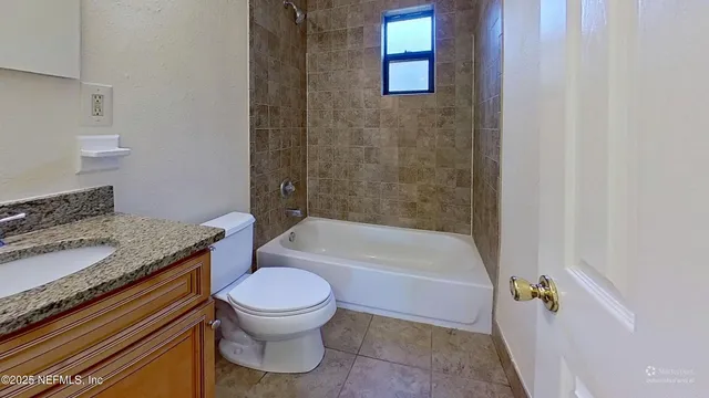 a bathroom with a granite countertop toilet a sink and bathtub