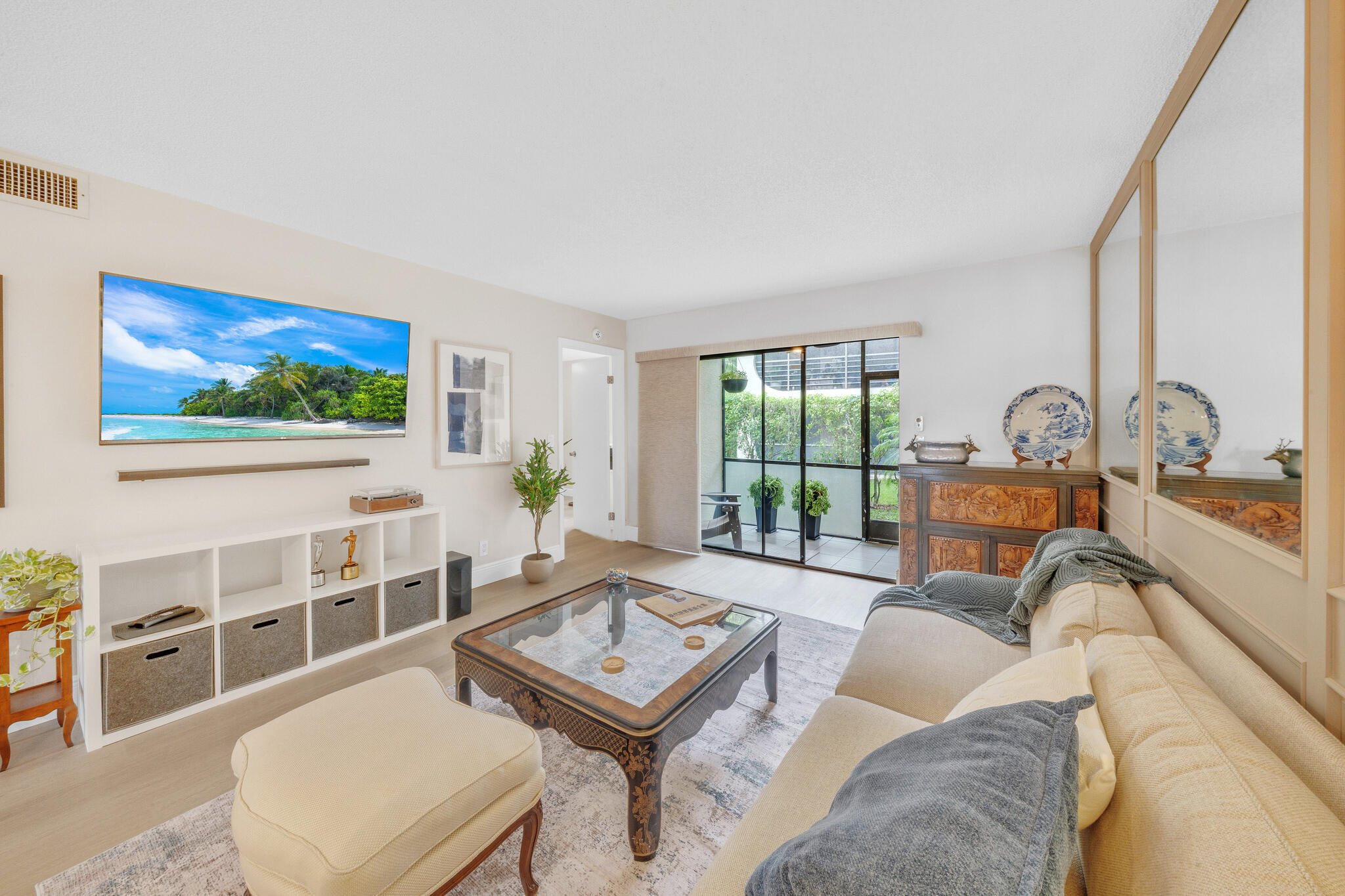 22136 Palms Way, Unit 103 Boca Raton, FL 33433 - Photo 10 of 42 a living room with furniture a flat screen tv and a floor to ceiling window