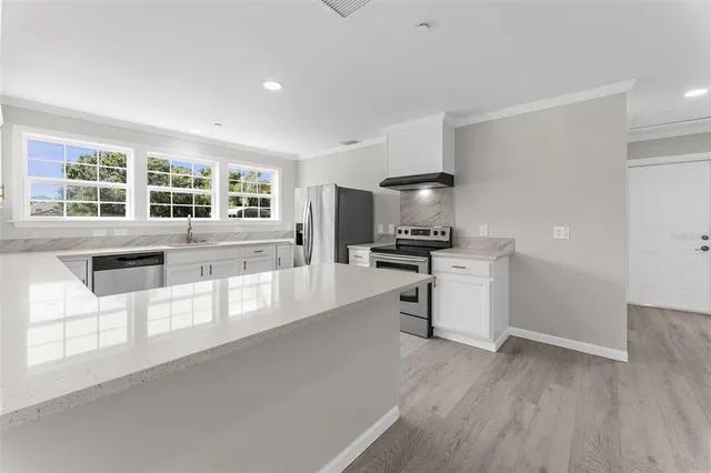 a kitchen with granite countertop a stove a sink and a refrigerator