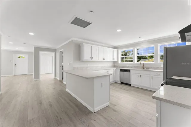 a kitchen with a sink stainless steel appliances and cabinets