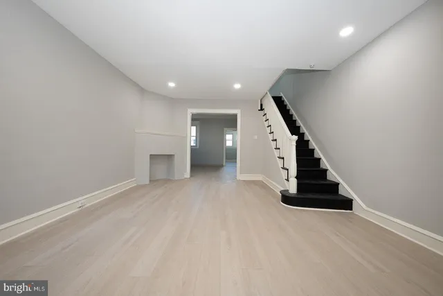 an empty room with wooden floor and entryway