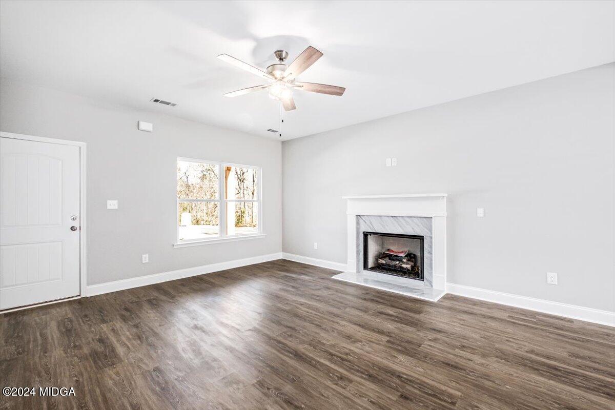 364 Walnut Grove Road Gray, GA 31032 - Photo 3 of 27 an empty room with large windows a fireplace and wooden floor