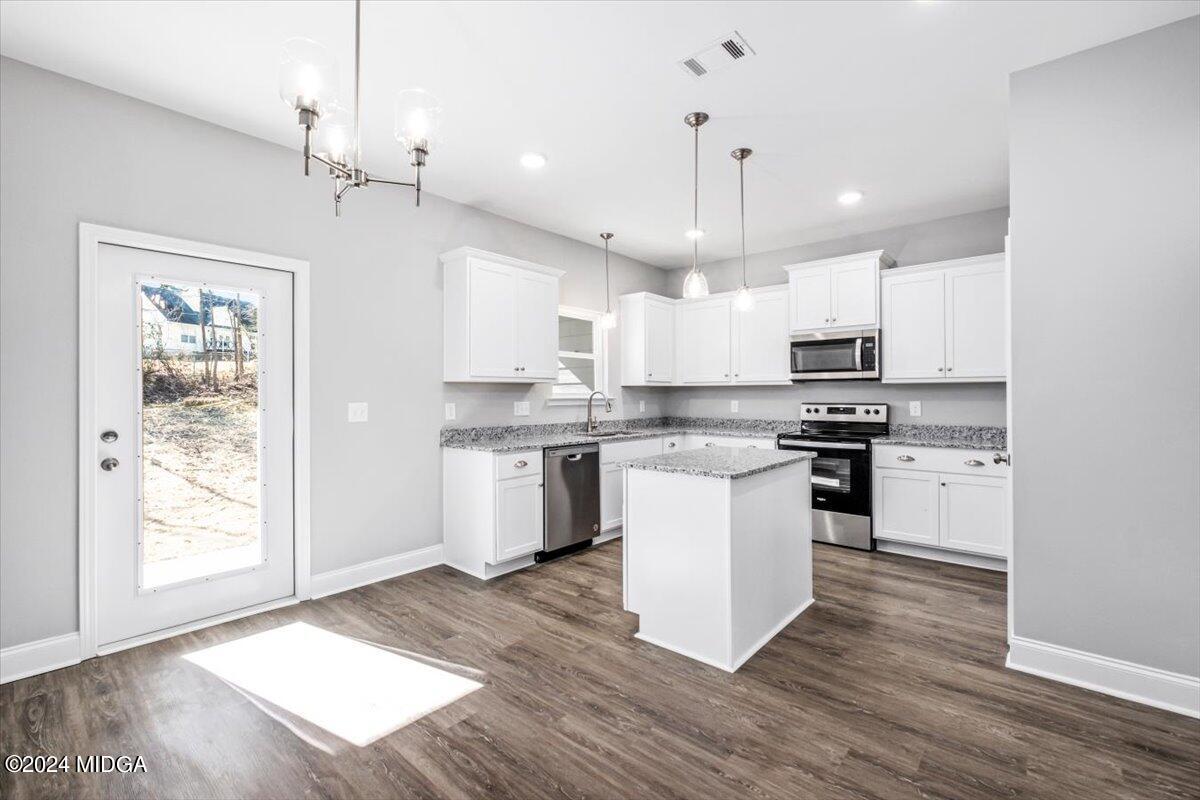 364 Walnut Grove Road Gray, GA 31032 - Photo 6 of 27 a kitchen with granite countertop a stove top oven a sink dishwasher a refrigerator and white cabinets with wooden floor