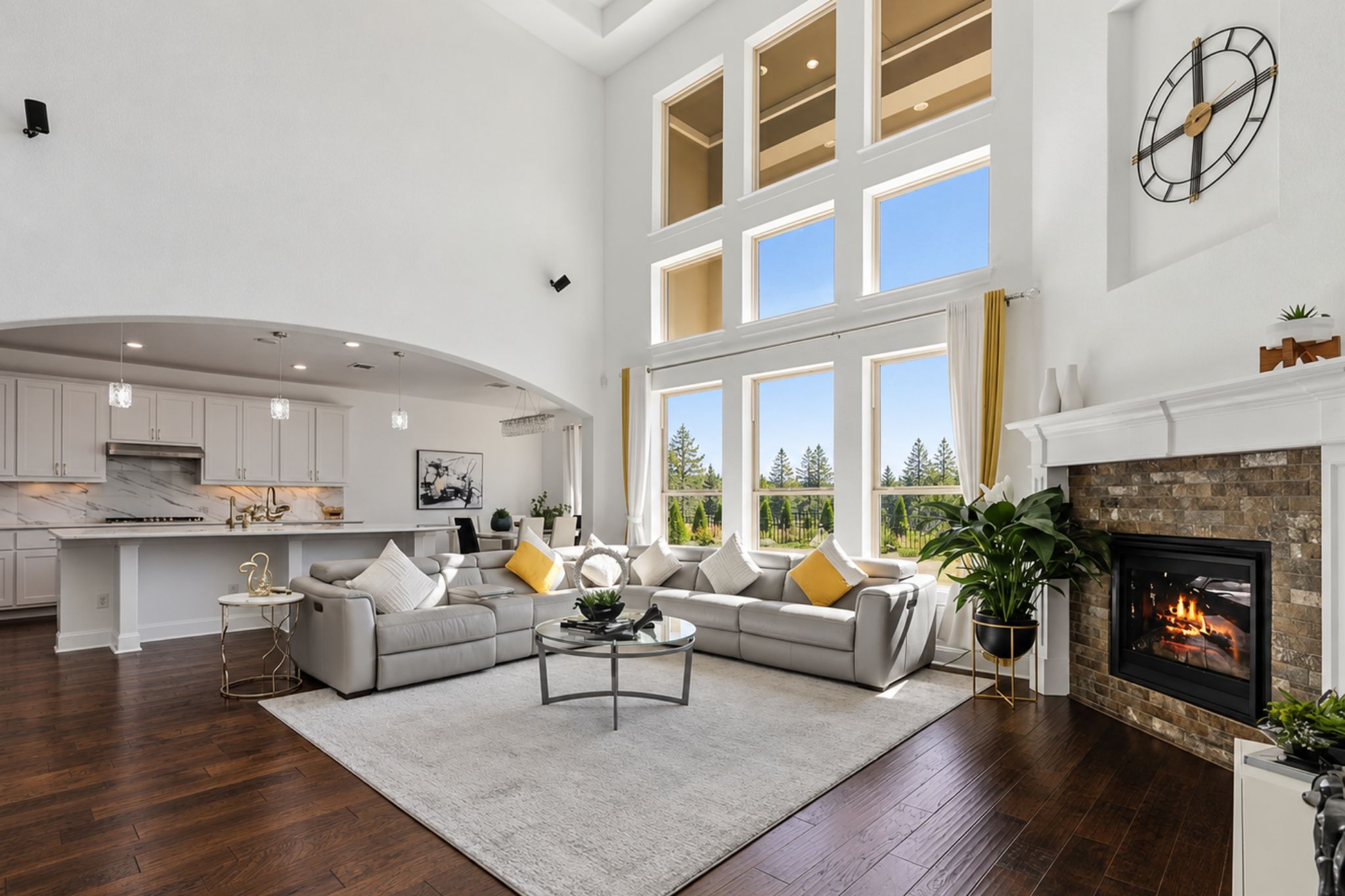 Soaring ceilings and walls of glass frame a magnificent fireplace in this expansive interior.