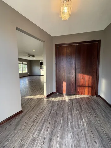 a view of an empty room with window and wooden floor