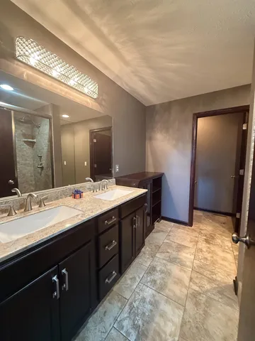 a bathroom with a granite countertop sink and a large mirror