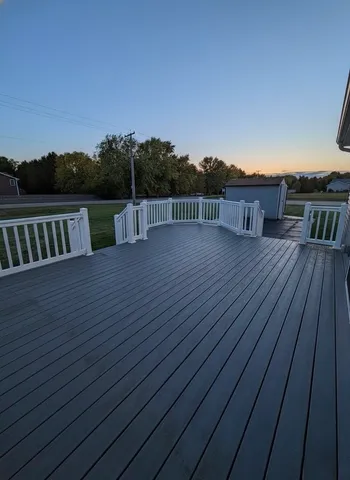 a view of deck with wooden floor and fence with a trees