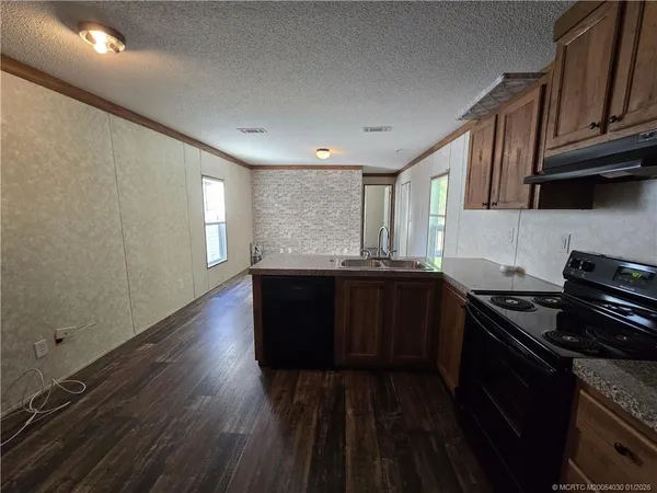 a kitchen with granite countertop a stove and cabinets