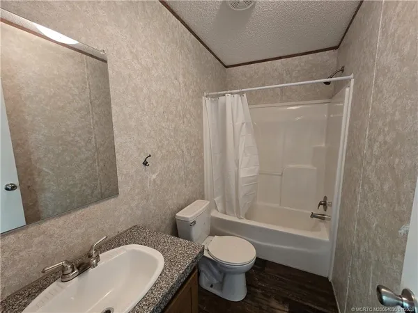 a bathroom with a granite countertop toilet sink and shower