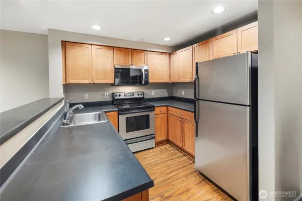 a kitchen with stainless steel appliances a refrigerator stove microwave and sink