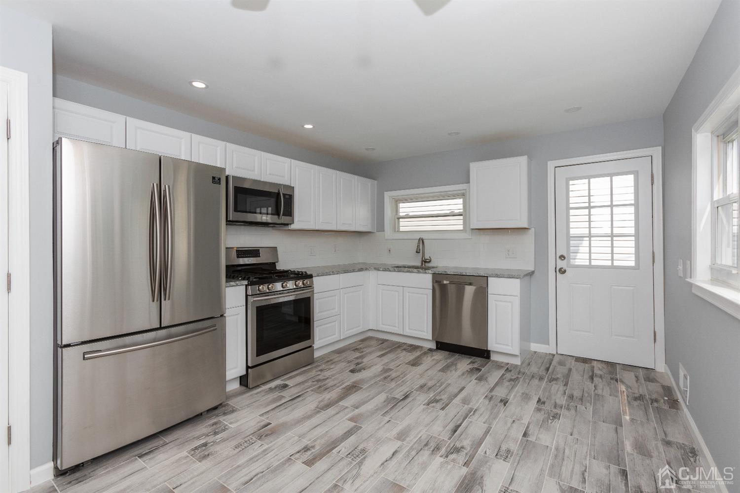70 Westminster Road Colonia, NJ 07067 - Photo 4 of 12 a kitchen with a refrigerator and a stove top oven