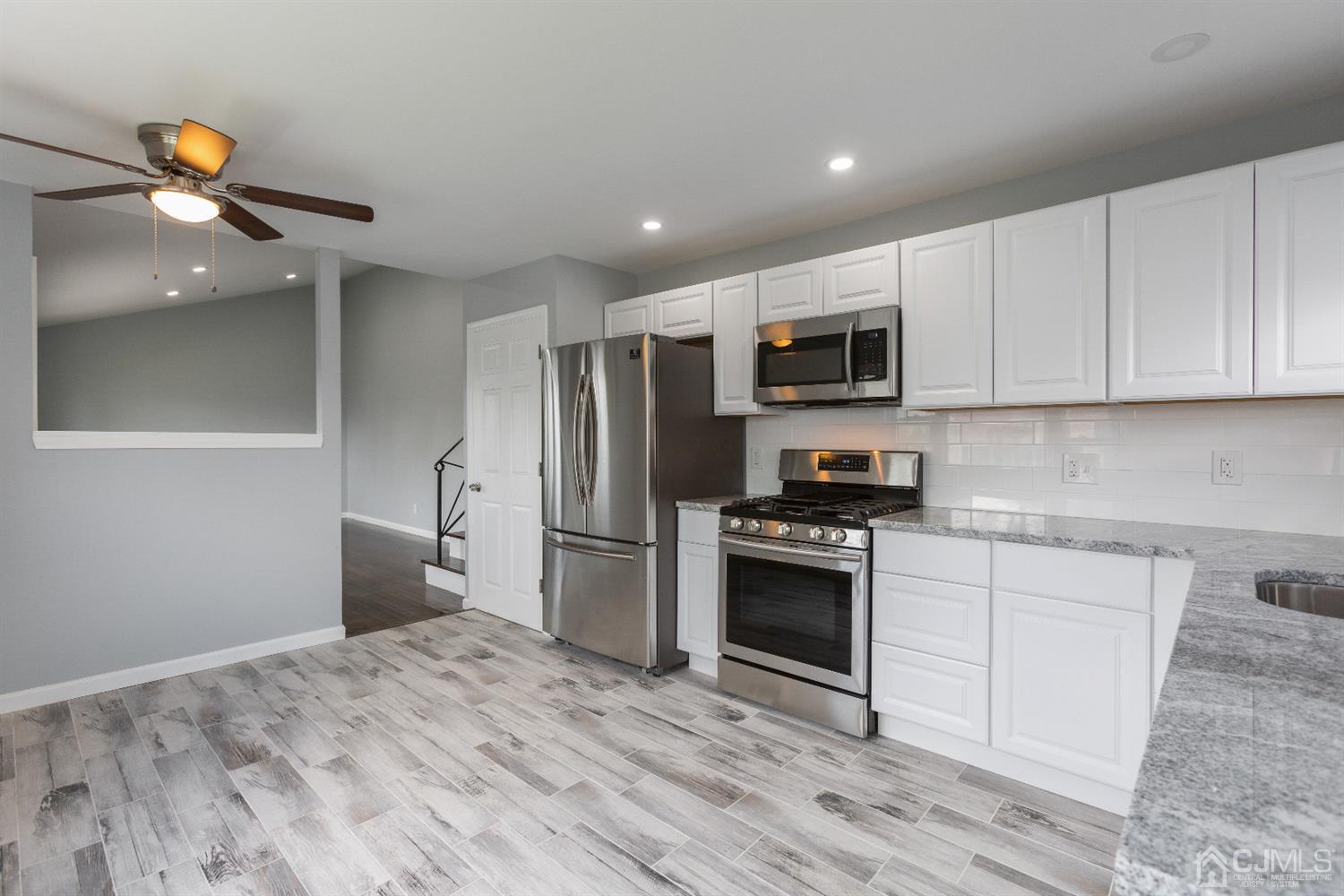 70 Westminster Road Colonia, NJ 07067 - Photo 5 of 12 a kitchen with stainless steel appliances granite countertop a stove a refrigerator and a microwave