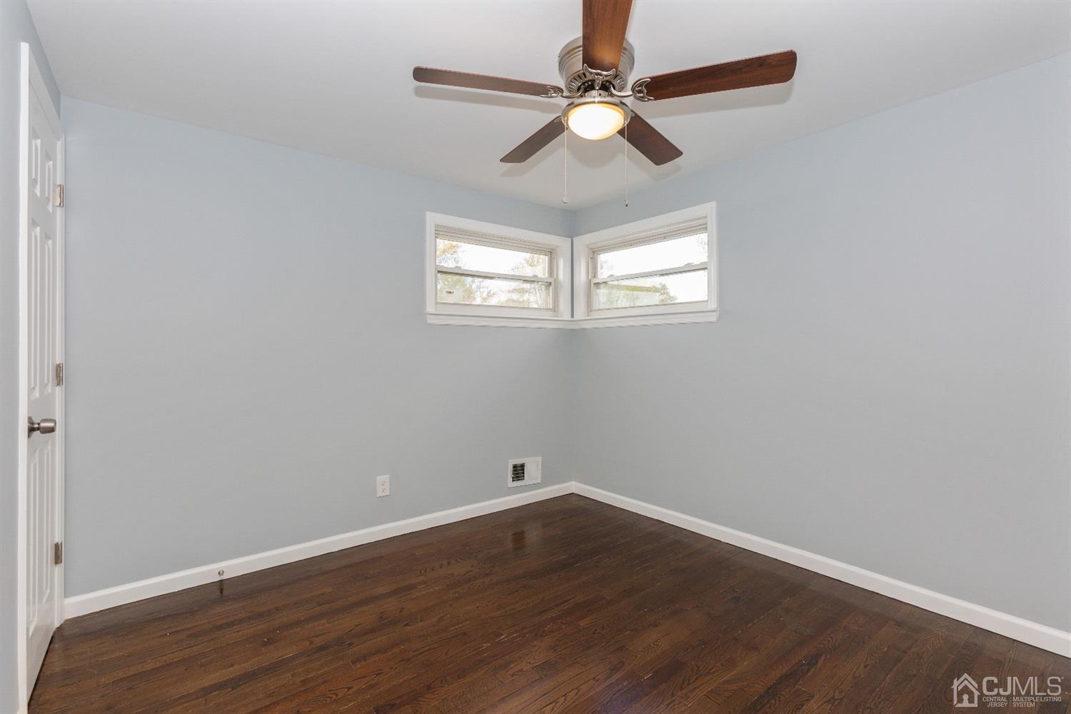 70 Westminster Road Colonia, NJ 07067 - Photo 8 of 12 an empty room with wooden floor fan and windows