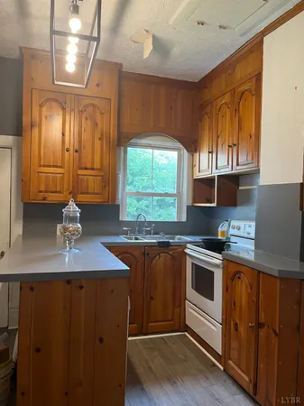 a kitchen with kitchen island granite countertop a sink cabinets and window