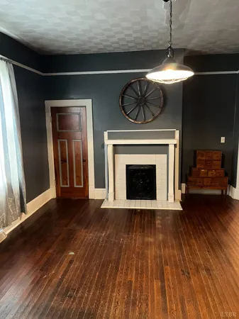 a view of a livingroom with wooden floor a fireplace and window