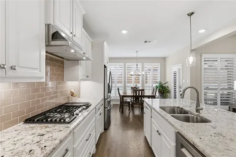 a kitchen with sink stove and cabinets