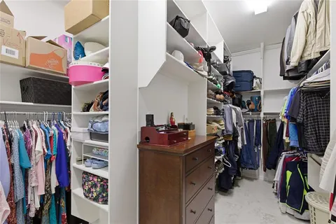 a view of walk in closet with clothes