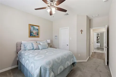a bedroom with a large bed and a chandelier